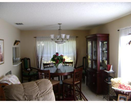 10719 Lake Oak Way Boca Raton, FL 33498 - Photo 3 of 4 a living room with furniture and a chandelier