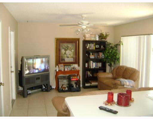 10719 Lake Oak Way Boca Raton, FL 33498 - Photo 4 of 4 a living room with furniture a lamp and a flat screen tv