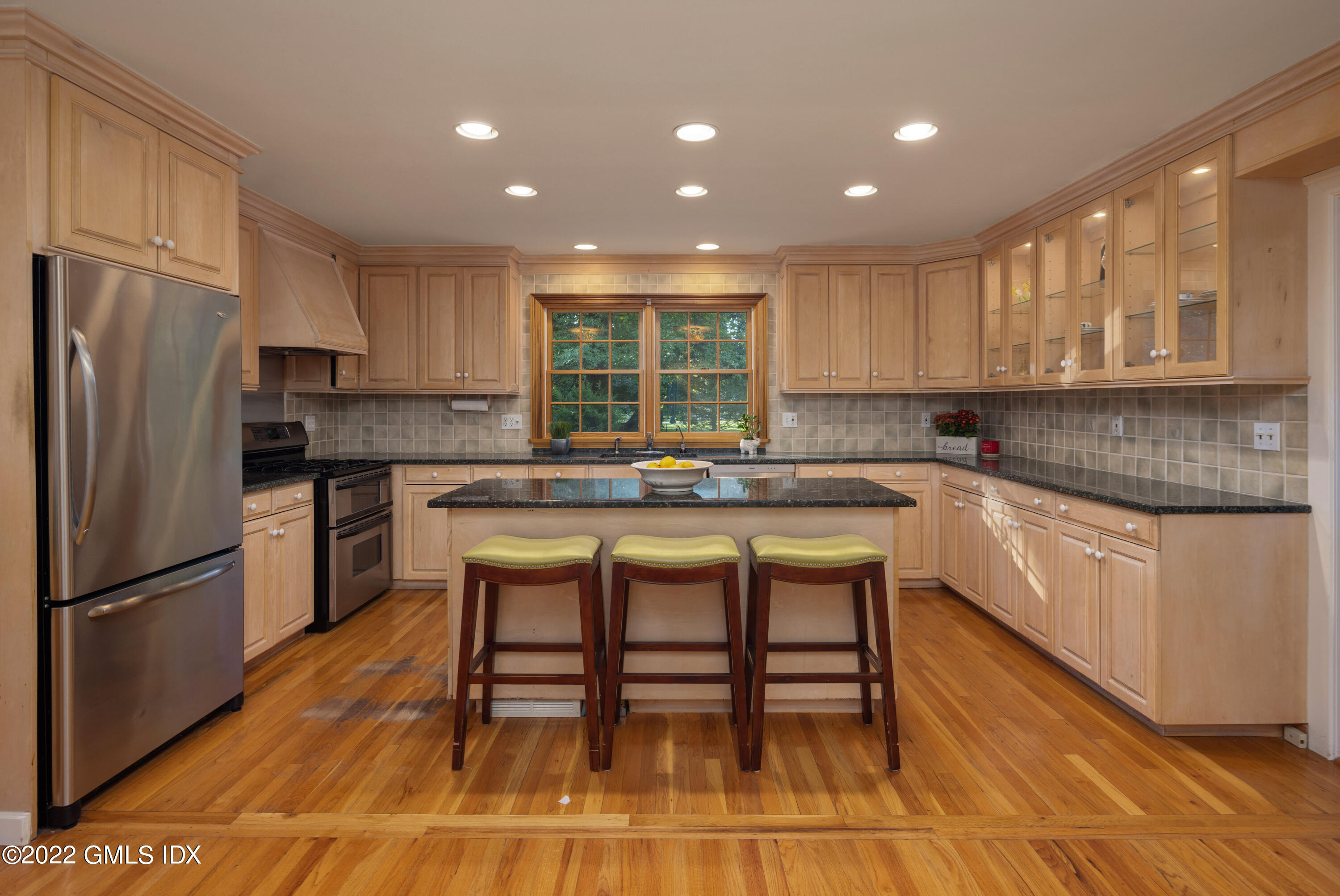 42 Angus Lane Greenwich, CT 06831 - Photo 12 of 39 a kitchen with kitchen island granite countertop a sink and wooden cabinets