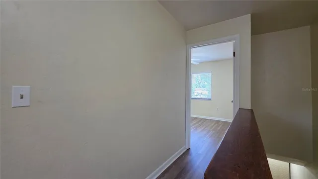 an empty room with a window and a fan