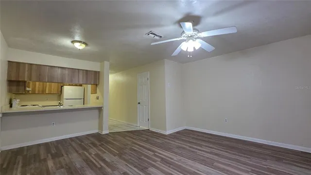 a view of a kitchen with a sink and dishwasher with wooden floor