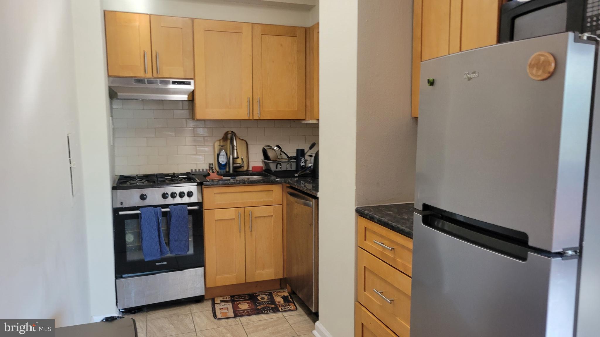 2101-17 Chestnut Street, Unit 215 Philadelphia, PA 19103 - Photo 2 of 10 a kitchen with a refrigerator and cabinets