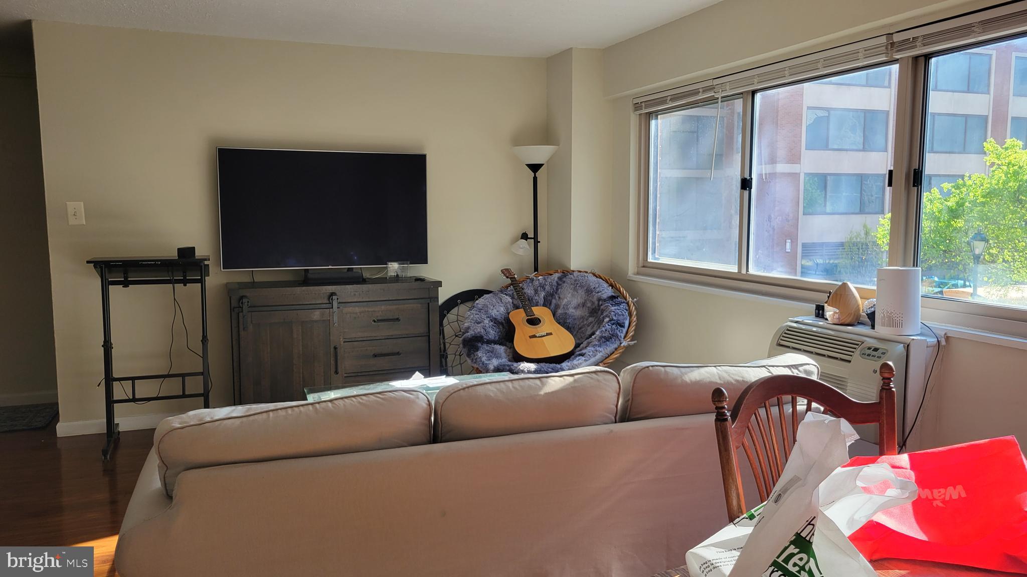 2101-17 Chestnut Street, Unit 215 Philadelphia, PA 19103 - Photo 3 of 10 a living room with furniture a flat screen tv and a large window
