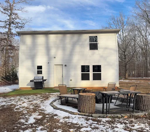 a backyard of a house with barbeque oven table and chairs