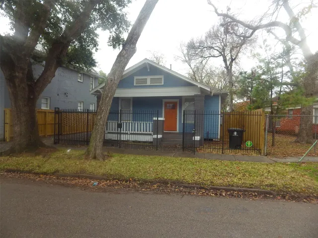 a view of a house with a yard and large tree