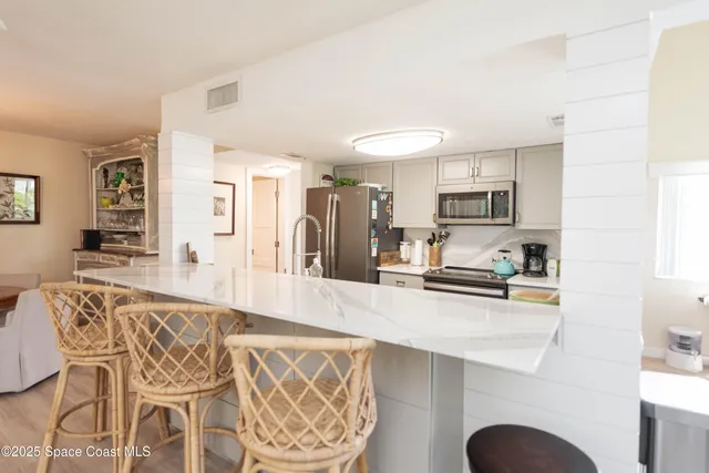 a kitchen with stainless steel appliances granite countertop a sink a stove top oven a counter space and cabinets