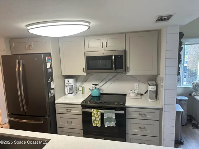 a kitchen with stainless steel appliances a stove and refrigerator