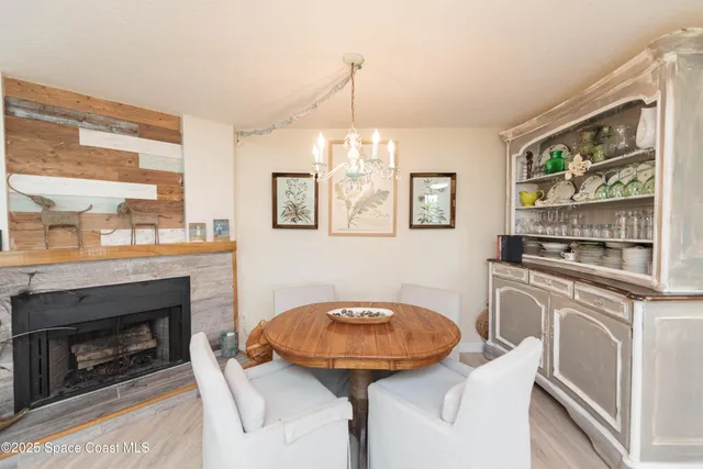 a view of a livingroom with furniture a fireplace and windows