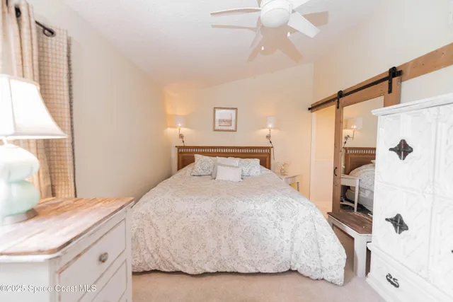 a spacious bedroom with a bed and a chandelier