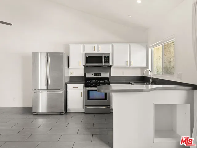 a kitchen with stainless steel appliances a refrigerator and a stove top oven
