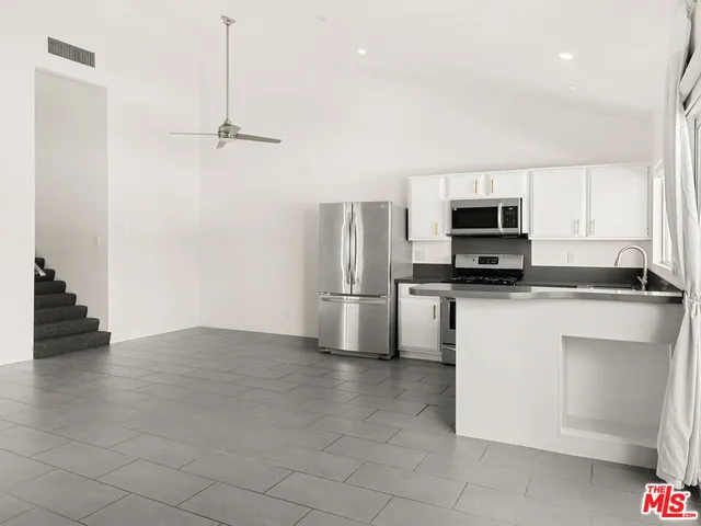 a kitchen with granite countertop white cabinets and appliances