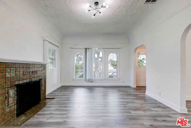 a view of empty room with wooden floor and fireplace