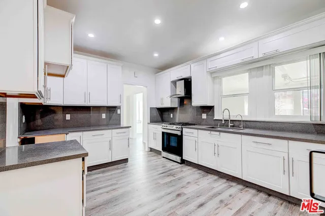 a kitchen with granite countertop white cabinets and white appliances