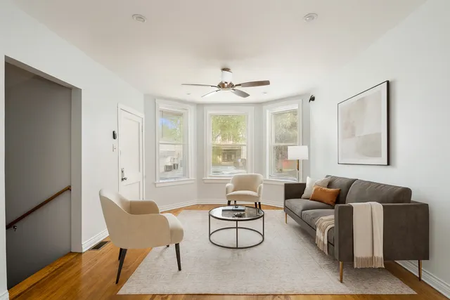 a living room with furniture a table and a large window