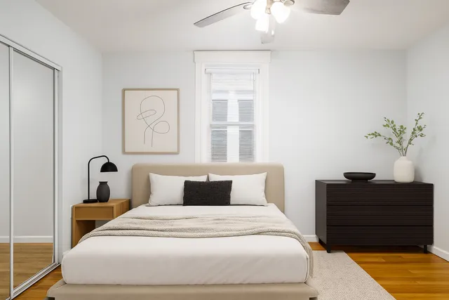 a bedroom with a bed and a potted plant
