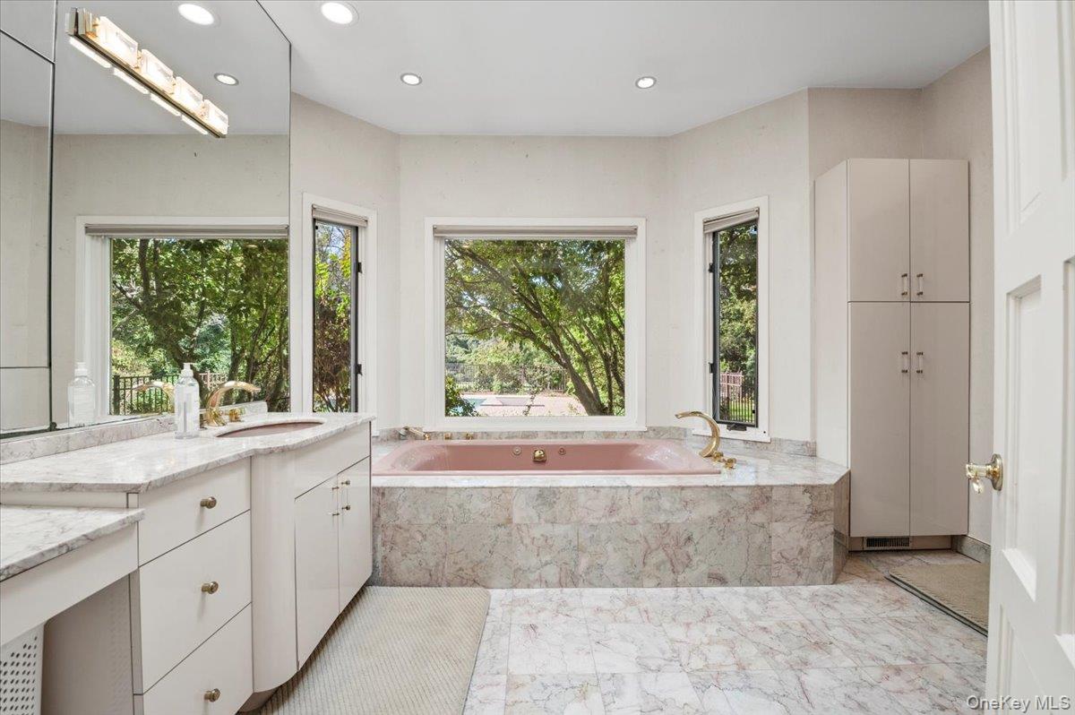 12 Ridge Court Glen Head, NY 11545 - Photo 24 of 46 Bathroom featuring recessed lighting, vanity, a bath, light marble finish floors, and healthy amount of natural light