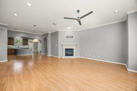a view of a big room with wooden floor and windows