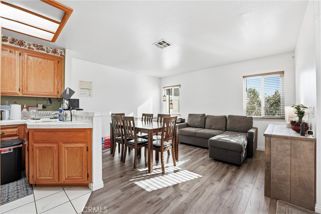 7639 Hillhurst Drive Riverside, CA 92508 - Photo 20 of 60 a living room with furniture and a dining table with wooden floor