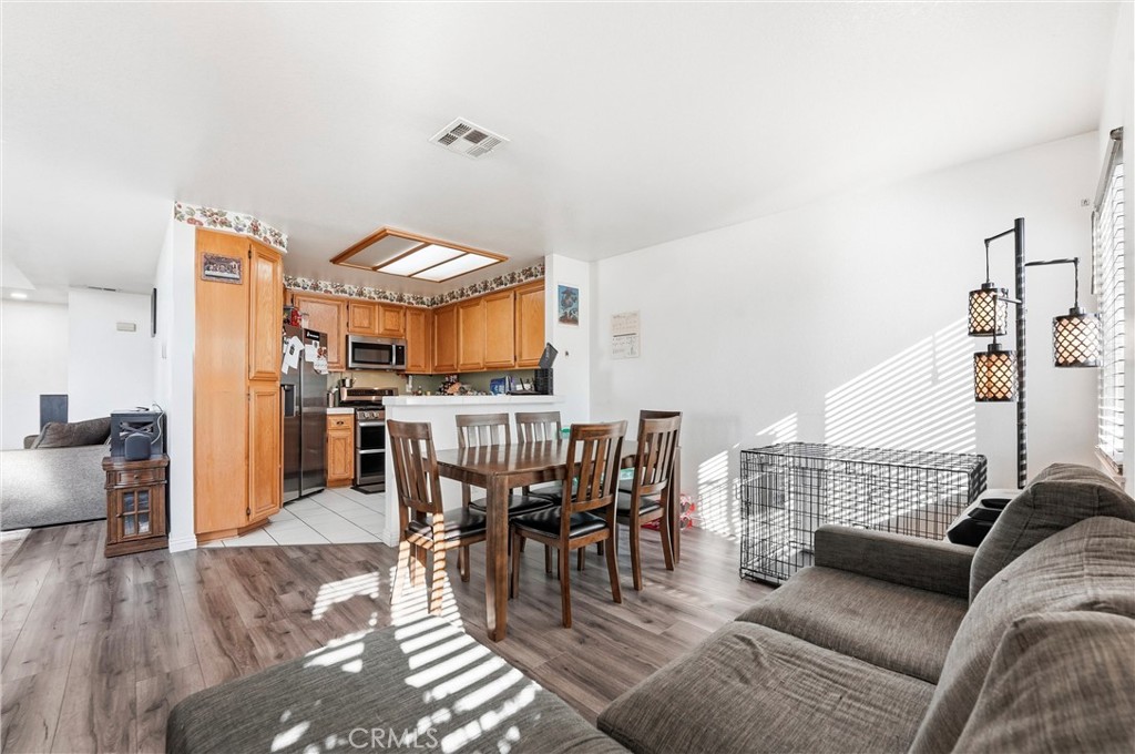 7639 Hillhurst Drive Riverside, CA 92508 - Photo 22 of 60 a living room with furniture a rug and kitchen view