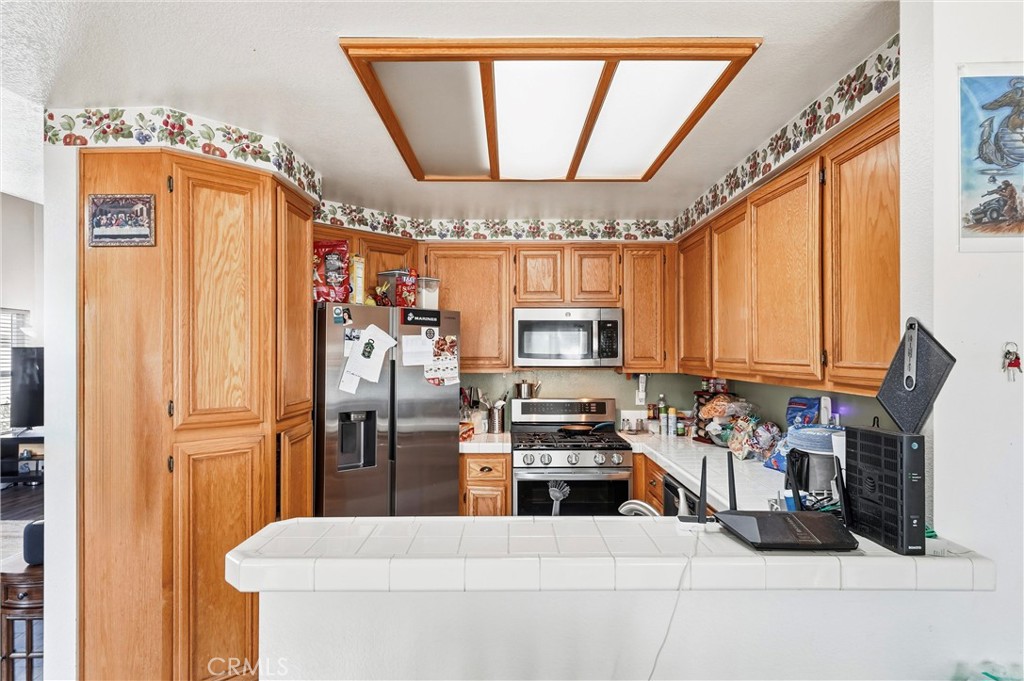 7639 Hillhurst Drive Riverside, CA 92508 - Photo 27 of 60 a kitchen with stainless steel appliances a refrigerator a stove a sink and a microwave