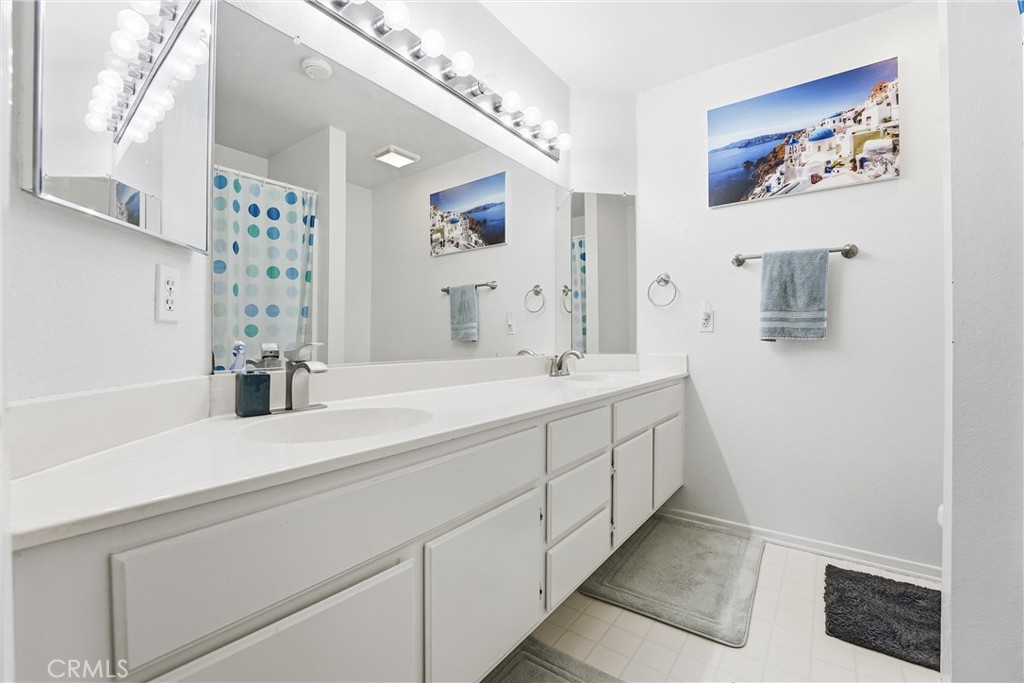 7639 Hillhurst Drive Riverside, CA 92508 - Photo 40 of 60 a bathroom with a double vanity sink a mirror and shower