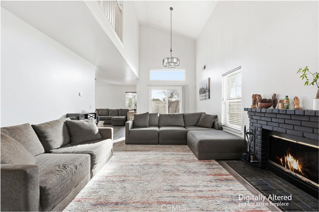 7639 Hillhurst Drive Riverside, CA 92508 - Photo 7 of 60 a living room with furniture a fireplace and a chandelier