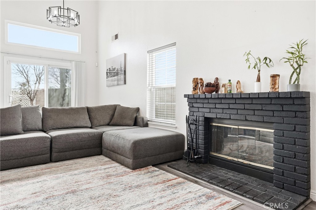 7639 Hillhurst Drive Riverside, CA 92508 - Photo 10 of 60 a living room with furniture a fireplace and a potted plant