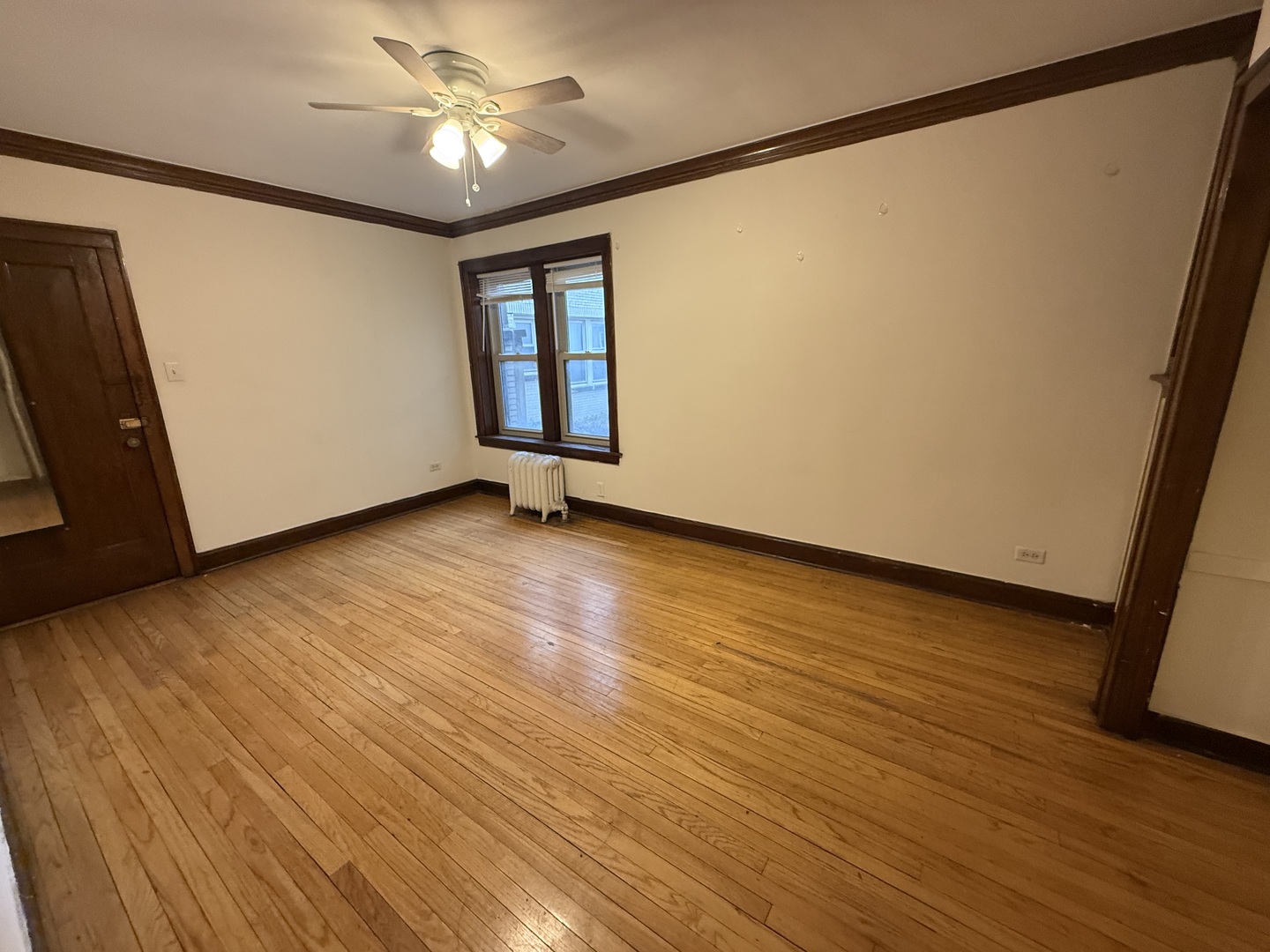 3152 North Linder Avenue, Unit 1 Chicago, IL 60641 - Photo 2 of 12 a view of an empty room with a window and wooden floor