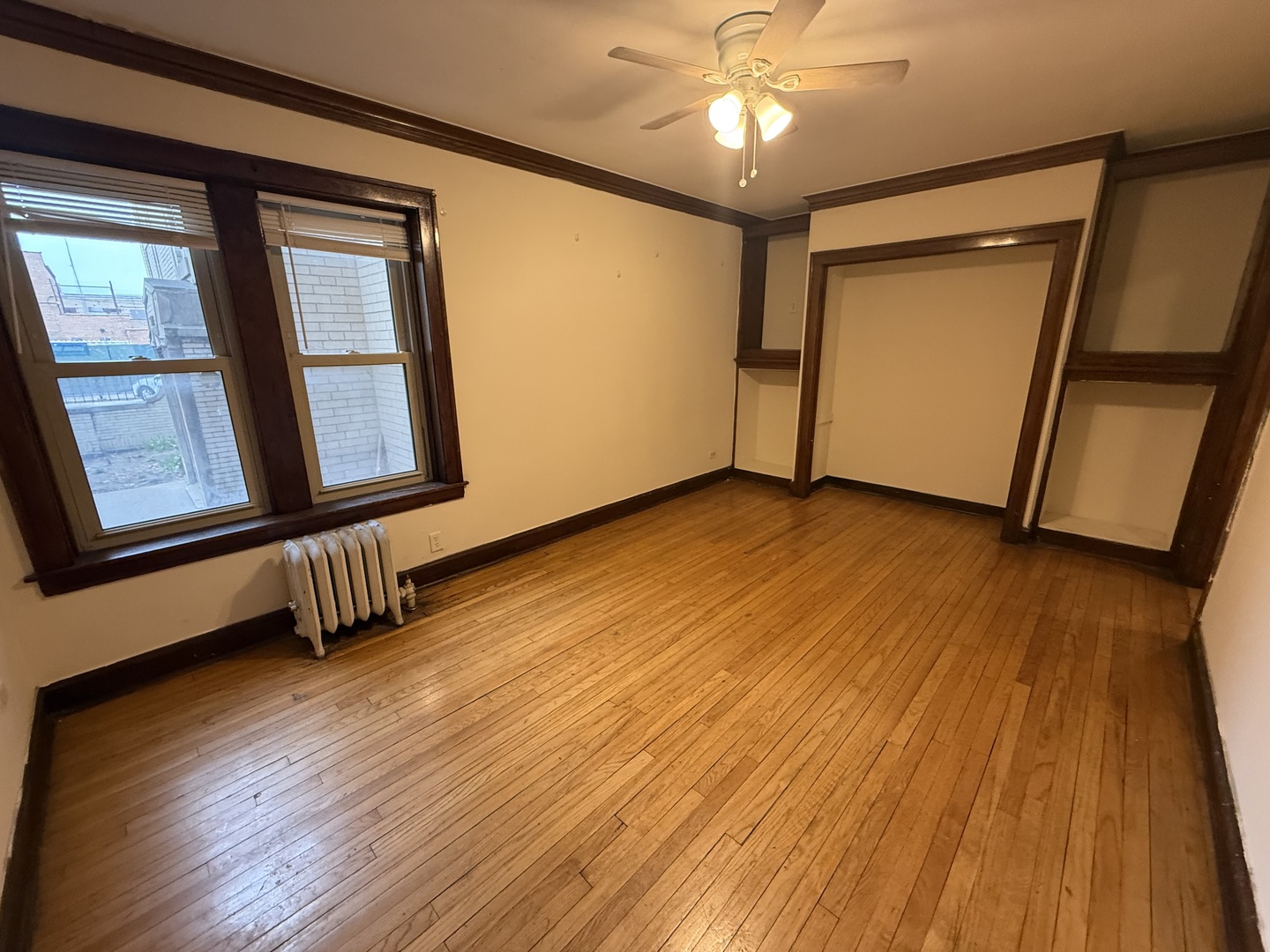 3152 North Linder Avenue, Unit 1 Chicago, IL 60641 - Photo 3 of 12 a view of an empty room with wooden floor and a window