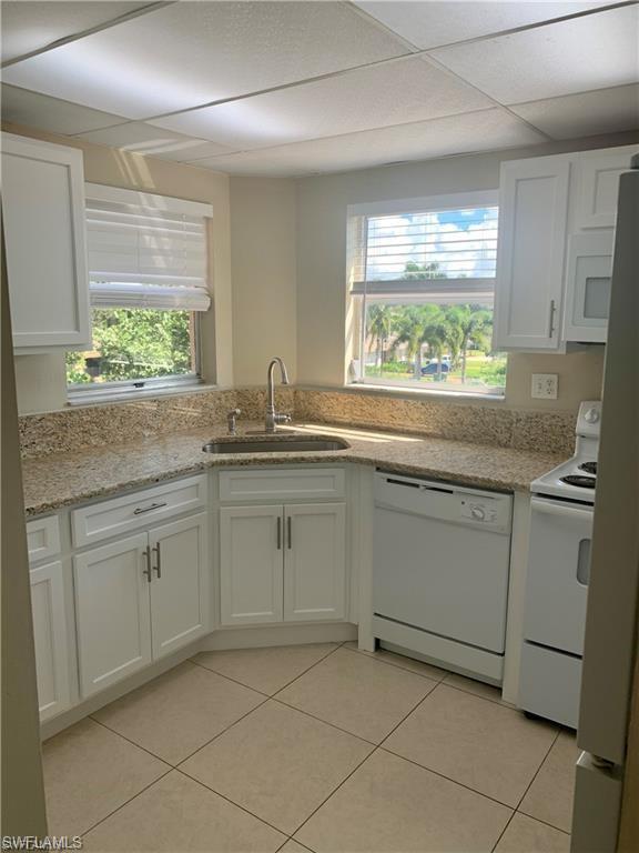 190 Pebble Beach Boulevard, Unit 301 Naples, FL 34113 - Photo 6 of 8 a kitchen with a sink and cabinets