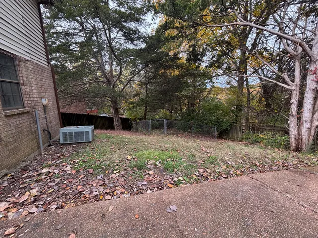 a view of a backyard with large trees