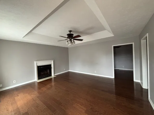 an empty room with wooden floor chandelier fan and closet