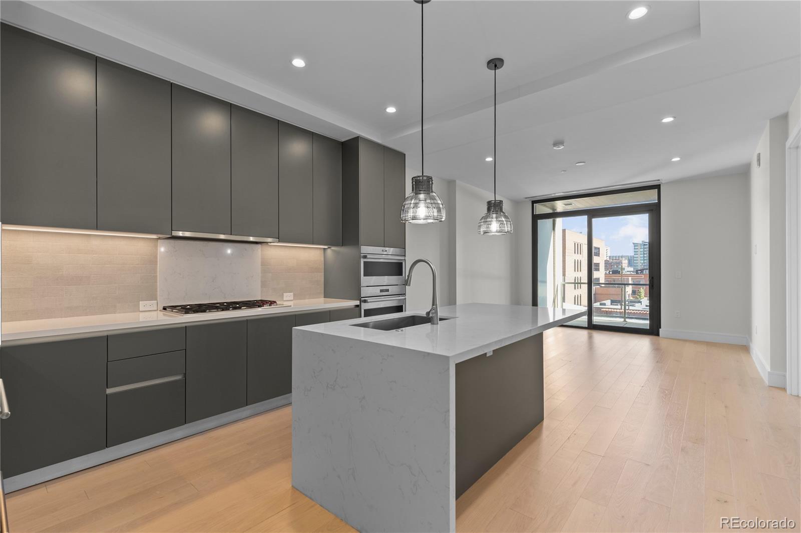 1901 Wazee Street, Unit 507 Denver, CO 80202 - Photo 1 of 45 a kitchen with kitchen island a sink stainless steel appliances and cabinets