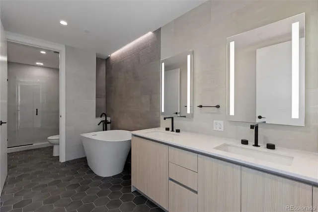a bathroom with a double vanity sink a mirror and a bathtub