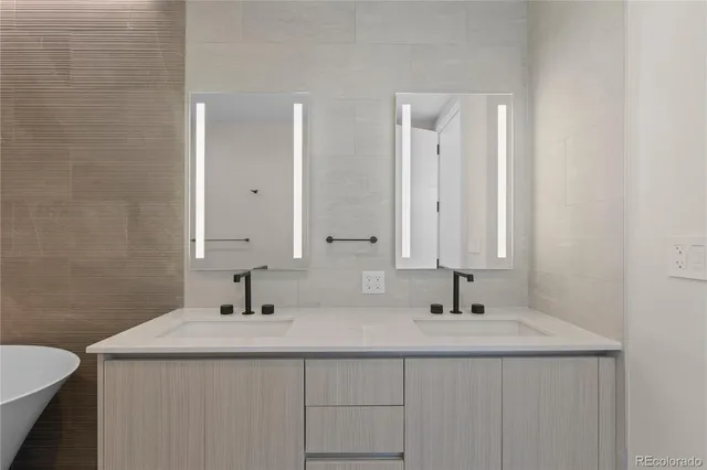 a bathroom with double sink and two mirror