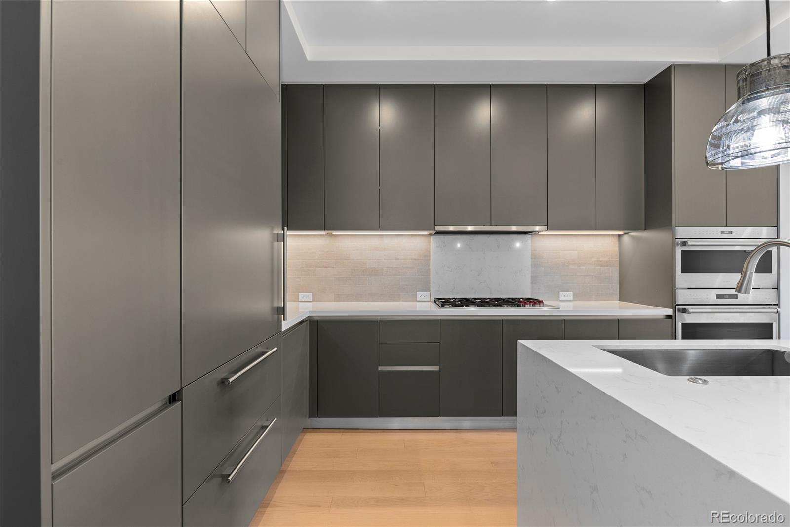 1901 Wazee Street, Unit 507 Denver, CO 80202 - Photo 8 of 45 a kitchen with kitchen island a sink stainless steel appliances and cabinets