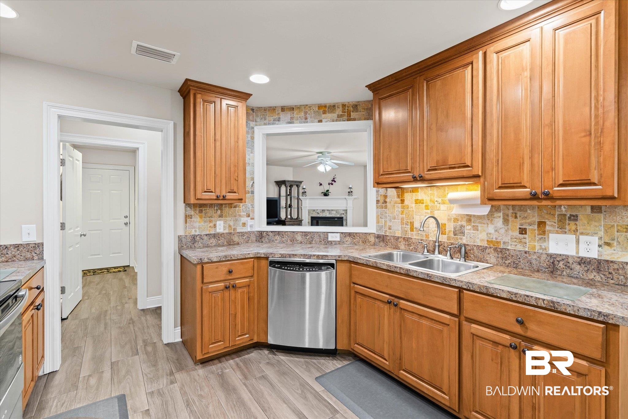 641 South Pine Street Foley, AL 36535 - Photo 14 of 22 Kitchen with tasteful backsplash, stainless steel appliances, brown cabinets, light wood-type flooring, and a ceiling fan
