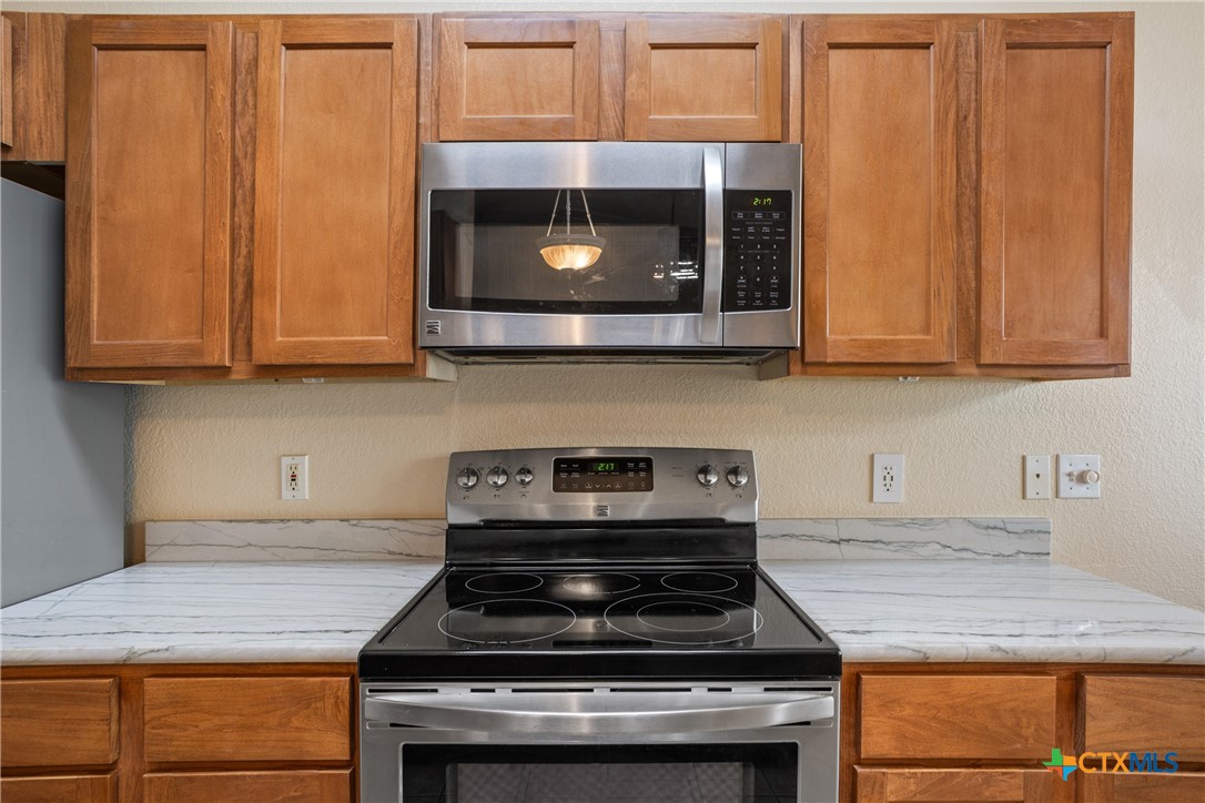 8 Sycamore Court Belton, TX 76513 - Photo 13 of 30 a kitchen with wooden cabinets stove top oven and sink