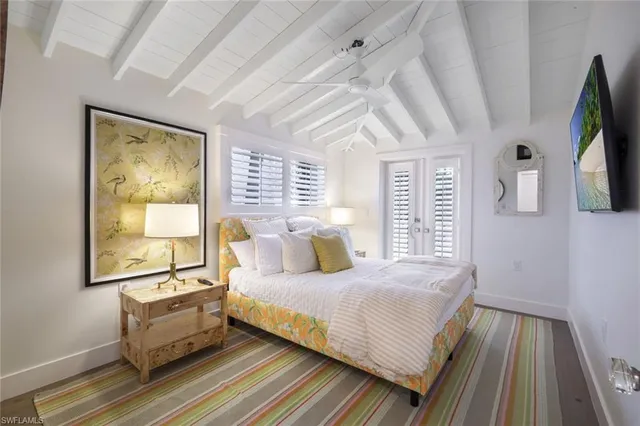 a bedroom with a bed wooden floor and window