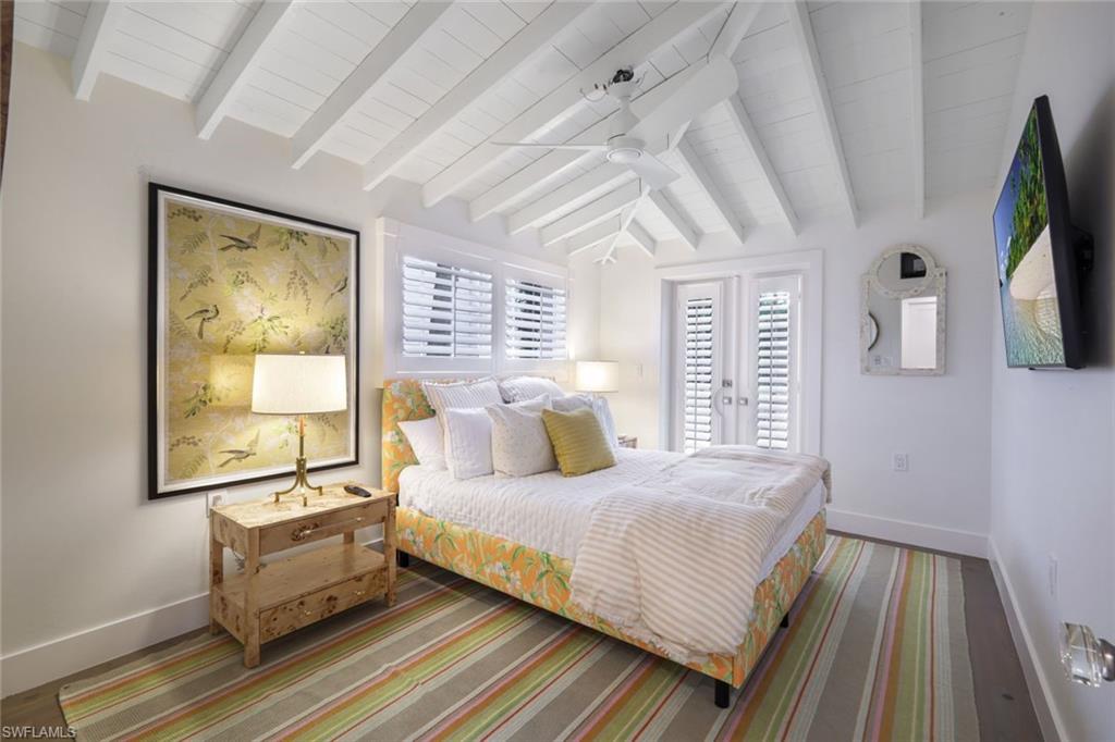 67 8th Avenue South Naples, FL 34102 - Photo 19 of 38 a bedroom with a bed wooden floor and window