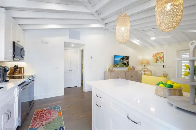 a kitchen with a sink dishwasher and a stove with wooden floor