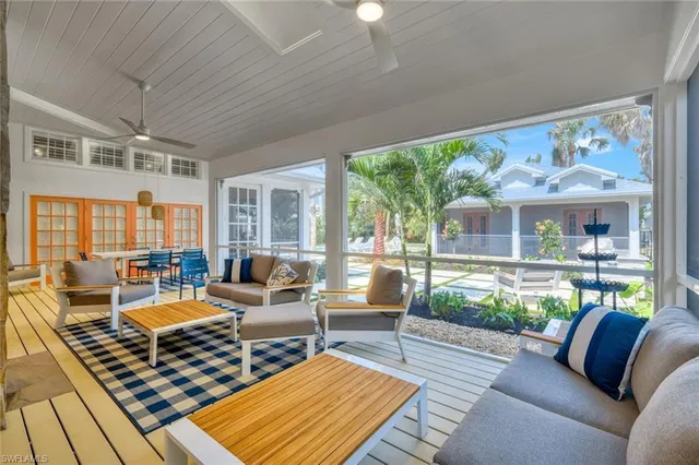 a living room with patio furniture and a large window