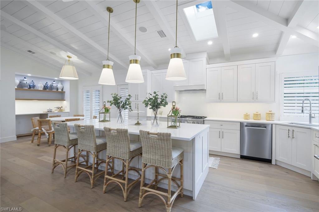 67 8th Avenue South Naples, FL 34102 - Photo 5 of 38 a kitchen with center island table and chairs in it