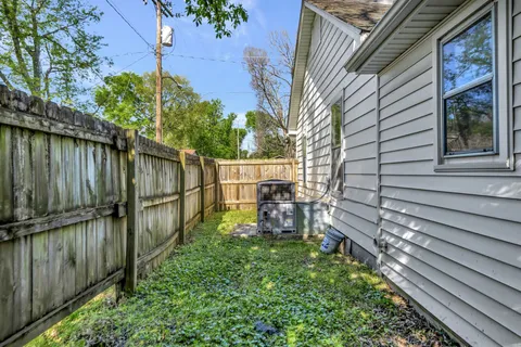 a view of a backyard with chairs and a large tree