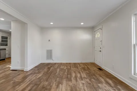 a view of empty room with wooden floor