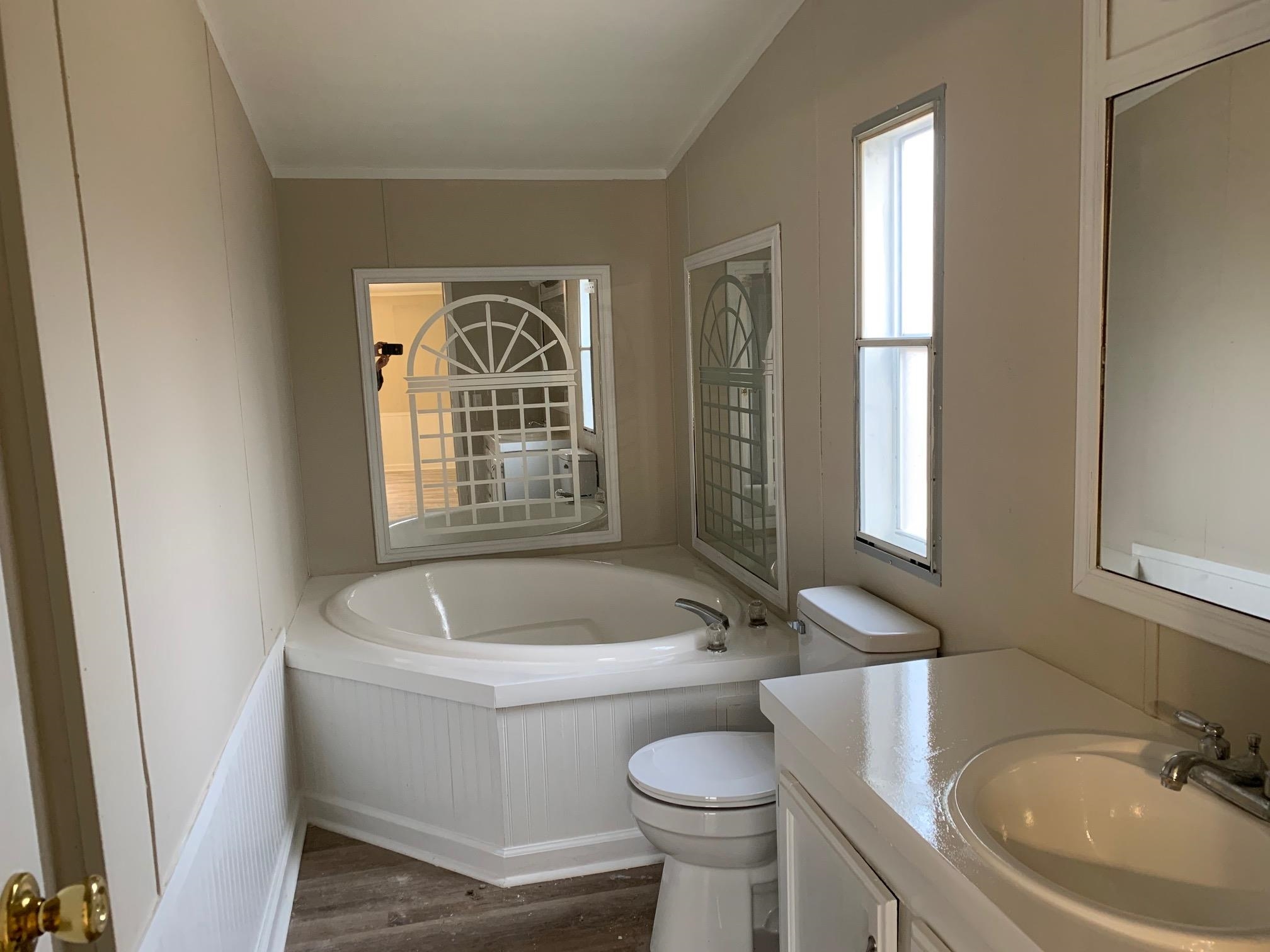1827 Burks Road Henning, TN 38041 - Photo 8 of 17 a bathroom with a sink a toilet a tub and window