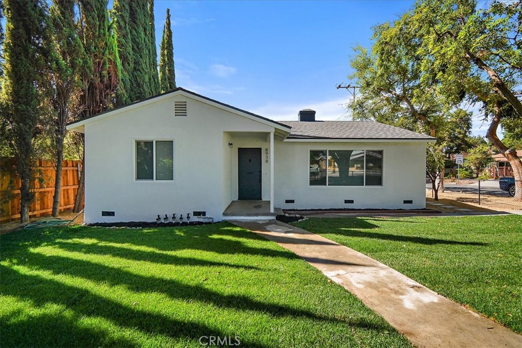 a view of a house with a yard and tree
