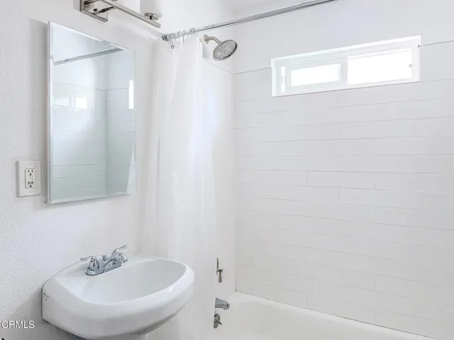 a bathroom with a sink a shower and a mirror