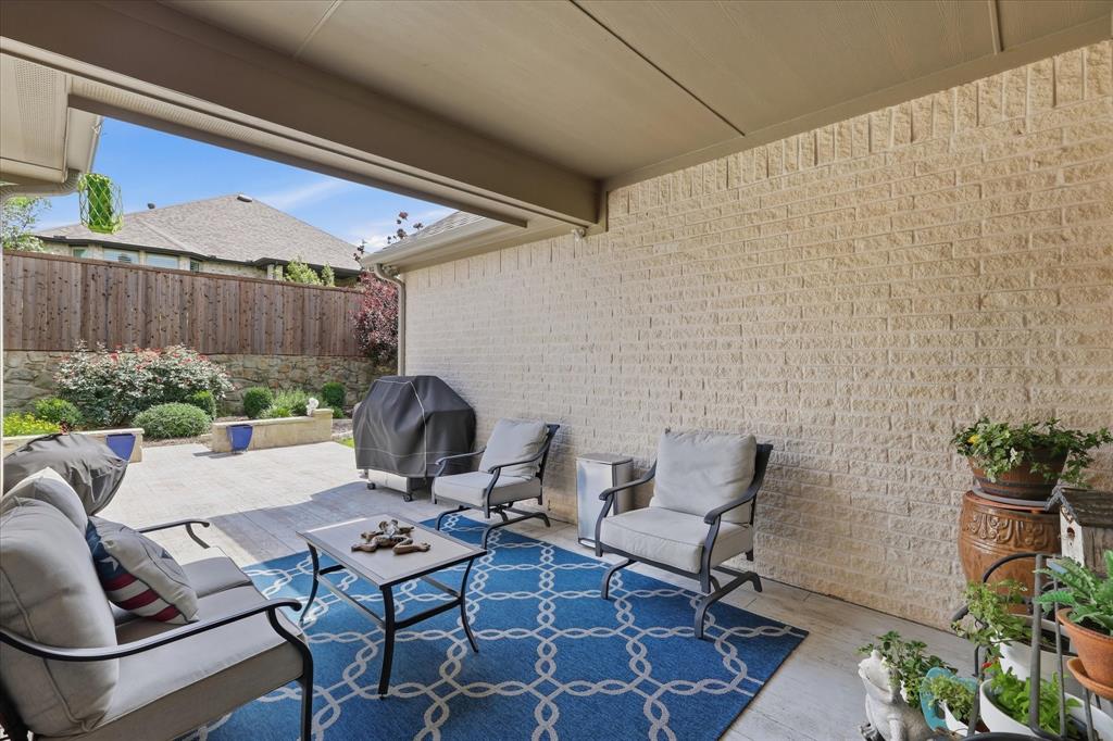9708 Surveyor Road Oak Point, TX 75068 - Photo 32 of 34 Covered outdoor patio featuring a concrete floor and light-colored brick wall