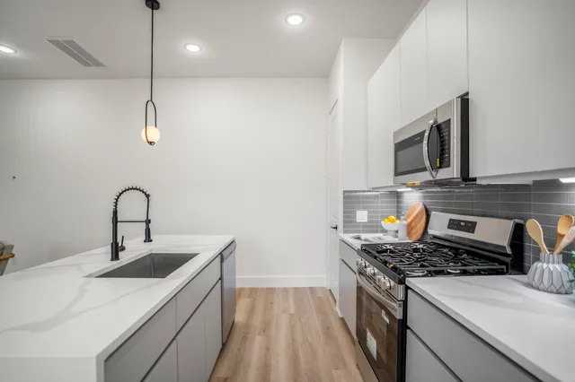 a kitchen with a sink and a stove top oven